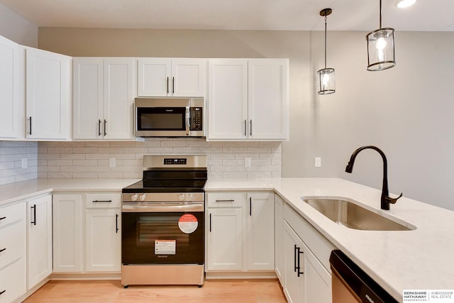 1917 Dahlman Rows Plz, Omaha, NE 68108 - kitchen featuring appliances with stainless steel finishes, a sink, light wood-type flooring, and backsplash