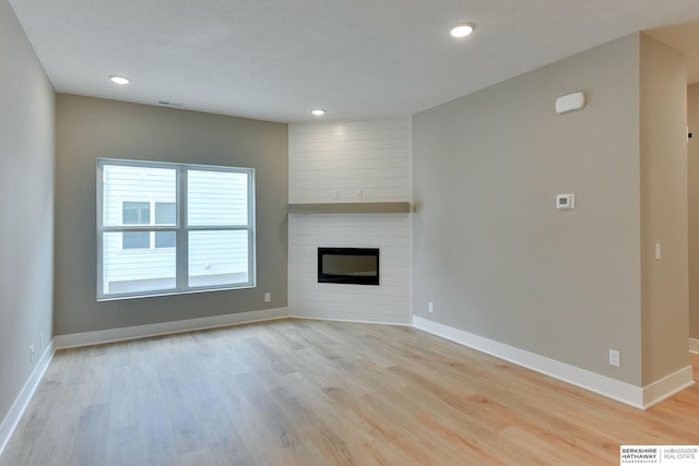 1917 Dahlman Rows Plz, Omaha, NE 68108 - unfurnished living room with light wood finished floors, baseboards, recessed lighting, and a fireplace