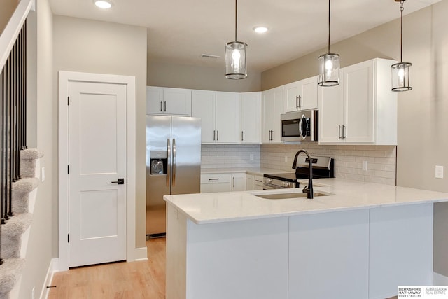 1921 Dahlman Rows Plz, Omaha, NE 68108 - kitchen featuring appliances with stainless steel finishes, light wood-type flooring, light countertops, tasteful backsplash, and a peninsula