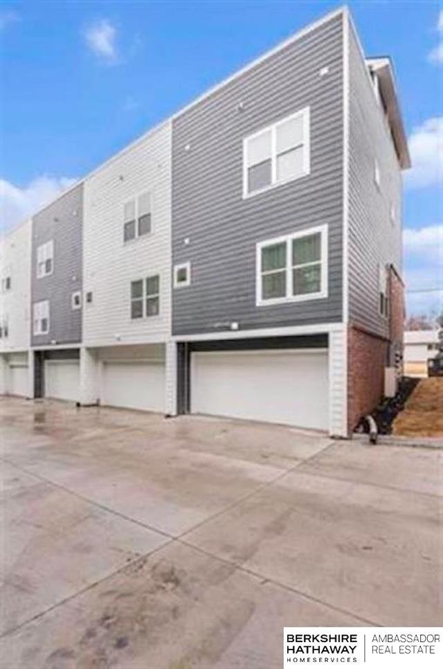 1921 Dahlman Rows Plz, Omaha, NE 68108 - back of house featuring a garage and concrete driveway