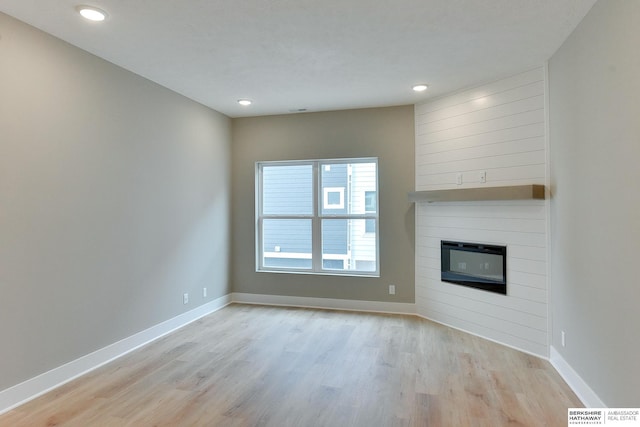 1921 Dahlman Rows Plz, Omaha, NE 68108 - unfurnished living room with wood finished floors, baseboards, a large fireplace, and recessed lighting