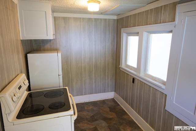 547 I St, Pawnee City, NE 68420 - kitchen with white appliances, wood walls, baseboards, white cabinets, and a textured ceiling