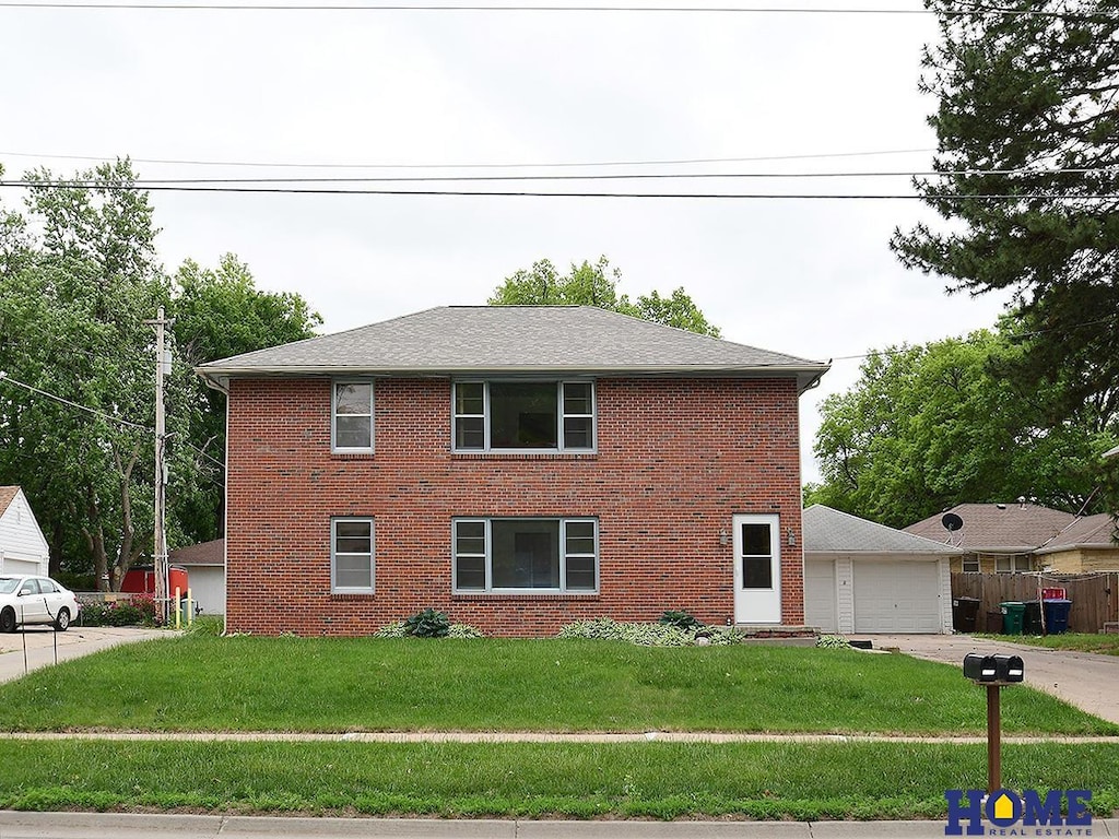 6009 Adams St, Lincoln, NE 68507 - view of property exterior with a yard, brick siding, and a garage