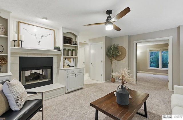 16712 V St, Omaha, NE 68135 - living area featuring light colored carpet, a tiled fireplace, a ceiling fan, baseboards, and built in features