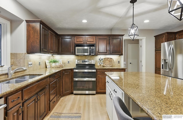 16712 V St, Omaha, NE 68135 - kitchen featuring stainless steel appliances, a sink, light wood-type flooring, light stone counters, and recessed lighting