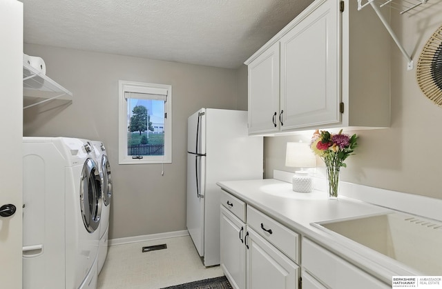 16712 V St, Omaha, NE 68135 - laundry room with baseboards, independent washer and dryer, cabinet space, and a textured ceiling