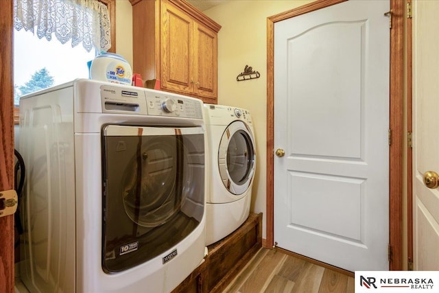 650 Heatherwood Dr, Fremont, NE 68025 - laundry room with cabinet space, washer and dryer, and wood finished floors