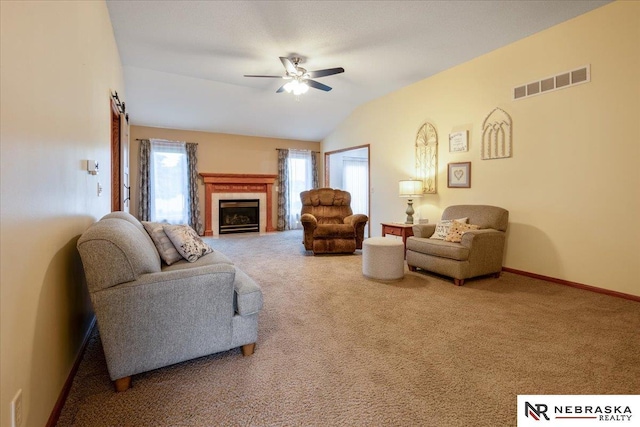 650 Heatherwood Dr, Fremont, NE 68025 - living area featuring carpet flooring, ceiling fan, vaulted ceiling, a fireplace, and baseboards