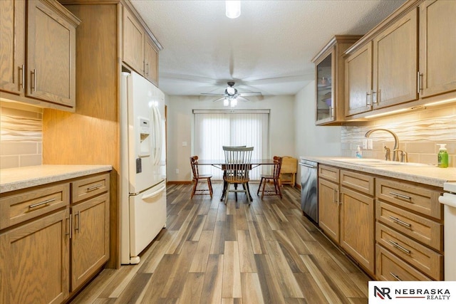650 Heatherwood Dr, Fremont, NE 68025 - kitchen with white refrigerator with ice dispenser, dishwasher, a sink, wood finished floors, and backsplash