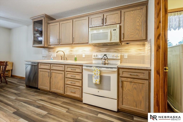 650 Heatherwood Dr, Fremont, NE 68025 - kitchen with white appliances, a sink, decorative backsplash, wood finished floors, and light countertops