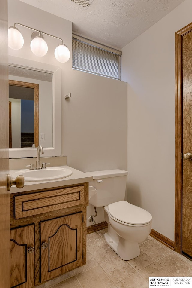 15010 Normandy Blvd, Bellevue, NE 68123 - half bathroom with toilet, vanity, baseboards, tile patterned floors, and a textured ceiling