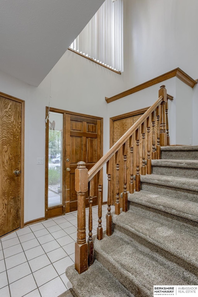 15010 Normandy Blvd, Bellevue, NE 68123 - stairs with tile patterned flooring, a towering ceiling, and baseboards