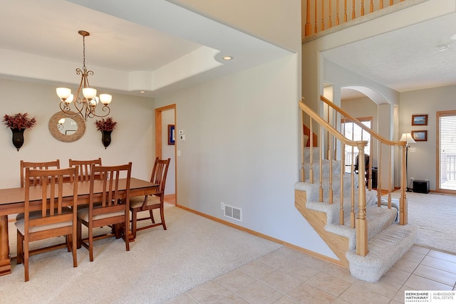 4804 Fountain Cir, Papillion, NE 68133 - dining room featuring carpet flooring, arched walkways, baseboards, a chandelier, and stairs
