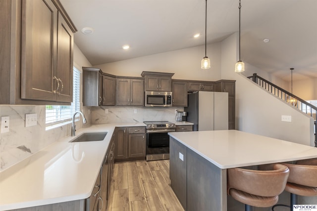8111 S 198th St, Gretna, NE 68028 - kitchen with appliances with stainless steel finishes, a sink, light wood-style flooring, tasteful backsplash, and lofted ceiling