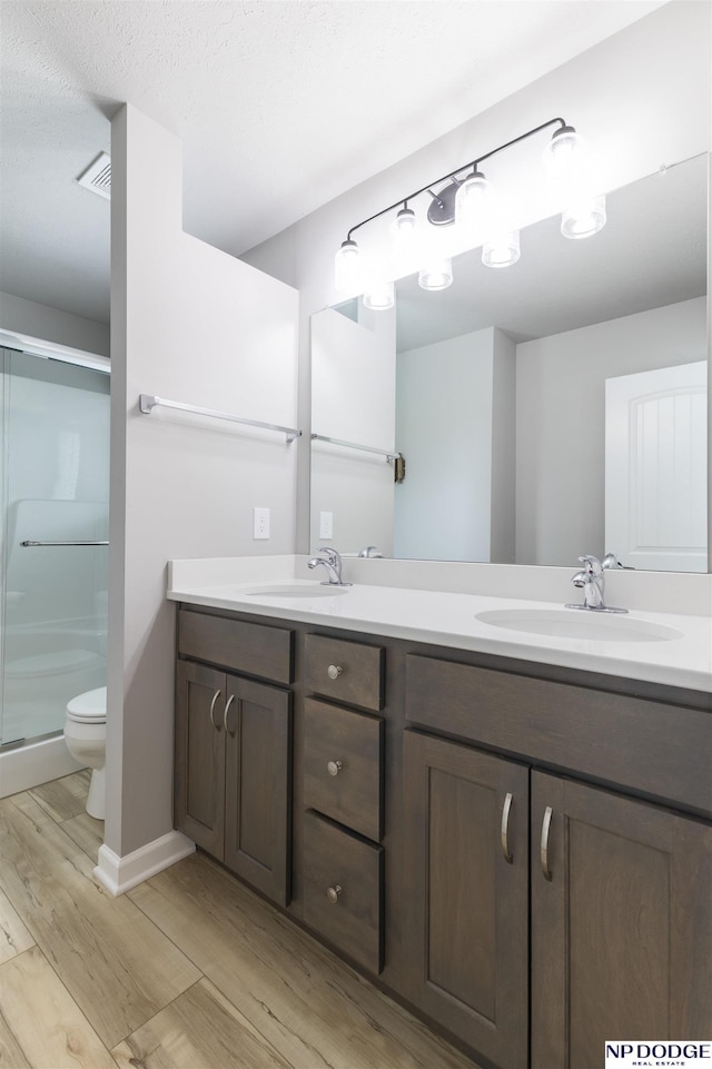 8111 S 198th St, Gretna, NE 68028 - bathroom featuring wood finished floors, toilet, a shower stall, and double vanity