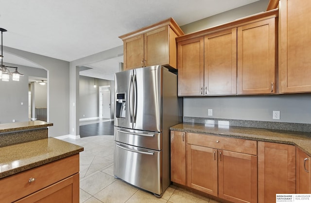 10022 S 177th St, Omaha, NE 68136 - kitchen featuring stainless steel refrigerator with ice dispenser, light tile patterned floors, brown cabinets, and arched walkways