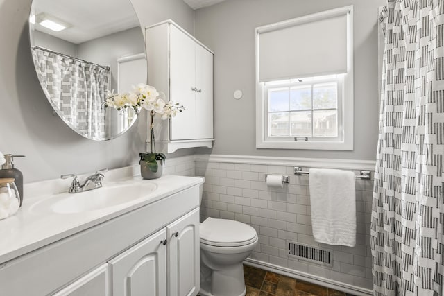 8207 Decatur St, Omaha, NE 68114 - full bathroom with vanity, toilet, tile walls, a wainscoted wall, and a shower with curtain