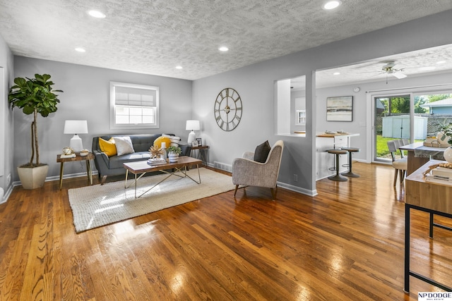 8207 Decatur St, Omaha, NE 68114 - living room with a textured ceiling, wood finished floors, baseboards, recessed lighting, and plenty of natural light