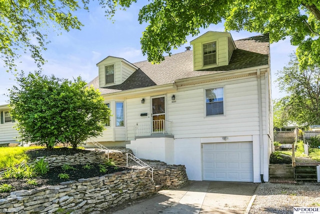 8207 Decatur St, Omaha, NE 68114 - new england style home with a garage, roof with shingles, and concrete driveway