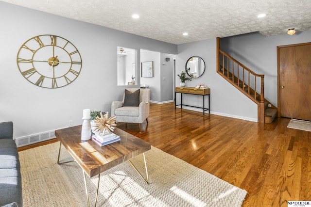 8207 Decatur St, Omaha, NE 68114 - living area featuring stairway, wood finished floors, baseboards, recessed lighting, and a textured ceiling