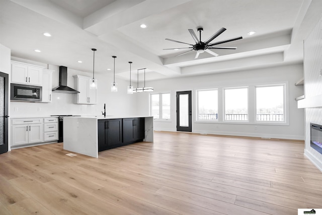 7949 Ponce Dr, Lincoln, NE 68516 - kitchen with wall chimney exhaust hood, built in microwave, range, open floor plan, and a glass covered fireplace