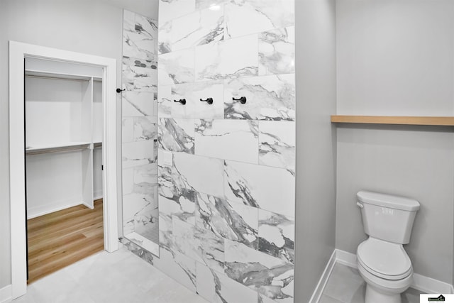 7949 Ponce Dr, Lincoln, NE 68516 - bathroom featuring tiled shower, toilet, and baseboards