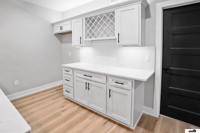 7949 Ponce Dr, Lincoln, NE 68516 - kitchen featuring baseboards, light wood-style floors, and white cabinets