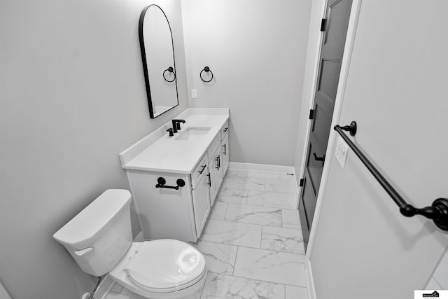 7949 Ponce Dr, Lincoln, NE 68516 - bathroom featuring marble look tiles, toilet, baseboards, and vanity