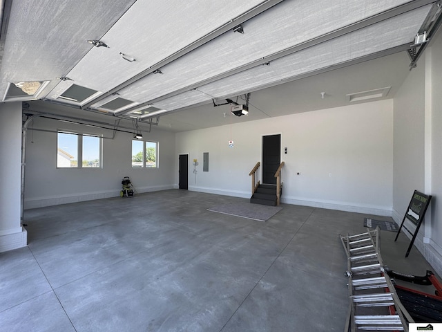 7949 Ponce Dr, Lincoln, NE 68516 - garage featuring a garage door opener, baseboards, and electric panel