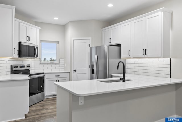 5948 Loxton St, Lincoln, NE 68526 - kitchen featuring stainless steel appliances, a peninsula, a sink, recessed lighting, and white cabinetry