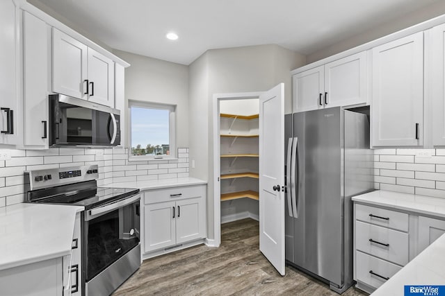 5948 Loxton St, Lincoln, NE 68526 - kitchen featuring appliances with stainless steel finishes, light wood-style floors, white cabinetry, recessed lighting, and decorative backsplash