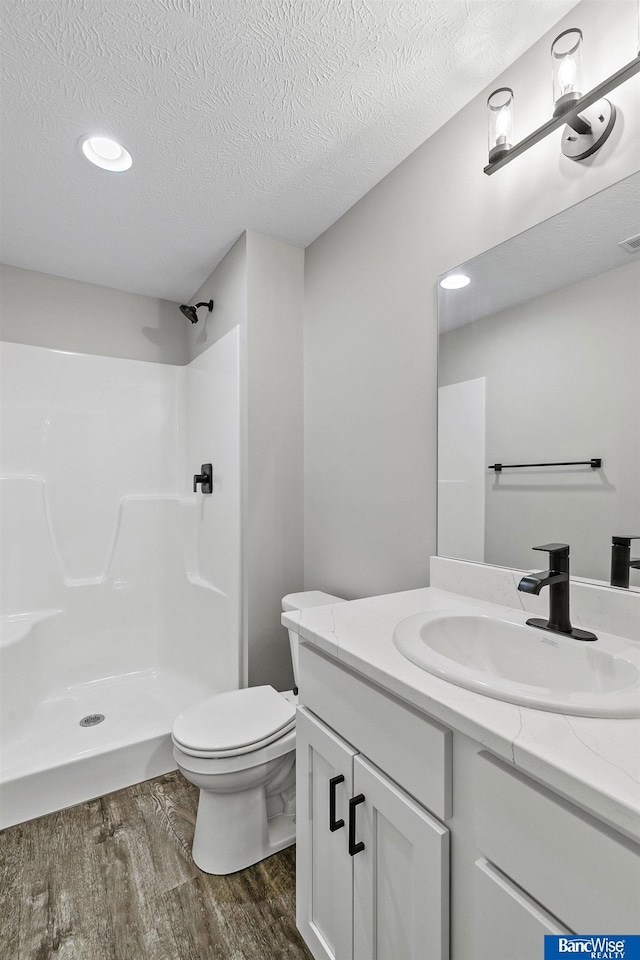5948 Loxton St, Lincoln, NE 68526 - full bath with wood finished floors, a shower, toilet, vanity, and a textured ceiling