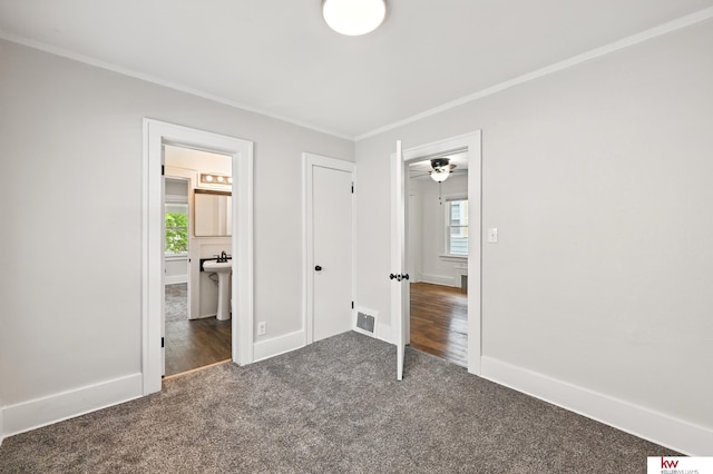2740 N 49th St, Omaha, NE 68104 - unfurnished bedroom featuring carpet, crown molding, baseboards, and connected bathroom