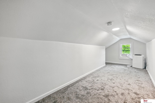 2740 N 49th St, Omaha, NE 68104 - bonus room with lofted ceiling, baseboards, a textured ceiling, and carpet floors