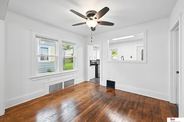 2740 N 49th St, Omaha, NE 68104 - unfurnished living room with radiator, hardwood / wood-style flooring, ceiling fan, baseboards, and ornamental molding