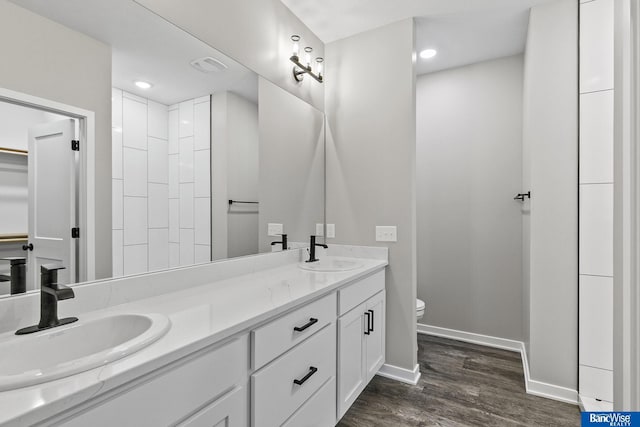 5956 Loxton St, Lincoln, NE 68526 - bathroom with wood finished floors, toilet, double vanity, baseboards, and recessed lighting