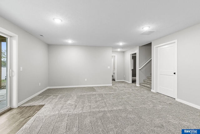 5956 Loxton St, Lincoln, NE 68526 - below grade area with stairway, baseboards, carpet, a textured ceiling, and recessed lighting