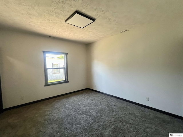 231 N Government St, Valentine, NE 69201 - empty room with dark carpet, baseboards, and a textured ceiling
