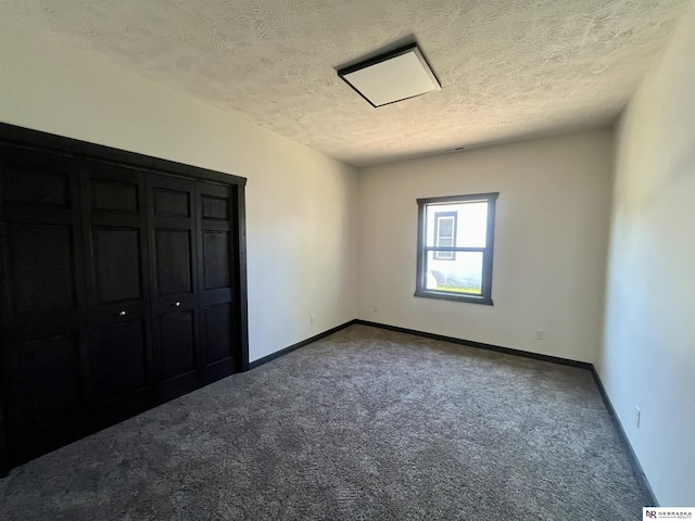231 N Government St, Valentine, NE 69201 - unfurnished bedroom with dark colored carpet, a textured ceiling, and baseboards