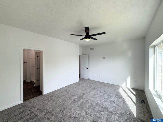 9434 Duckhorn Dr, Lincoln, NE 68526 - unfurnished bedroom featuring carpet flooring, baseboards, a textured ceiling, and a ceiling fan