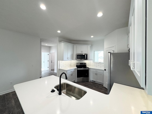 9434 Duckhorn Dr, Lincoln, NE 68526 - kitchen with stainless steel appliances, a sink, dark wood-style floors, decorative backsplash, and recessed lighting