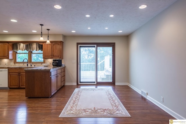 10919 N 69th St, Omaha, NE 68152 - kitchen with a sink, brown cabinetry, recessed lighting, tasteful backsplash, and hanging light fixtures