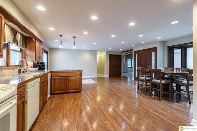 10919 N 69th St, Omaha, NE 68152 - kitchen featuring a sink, white appliances, a peninsula, wood finished floors, and recessed lighting