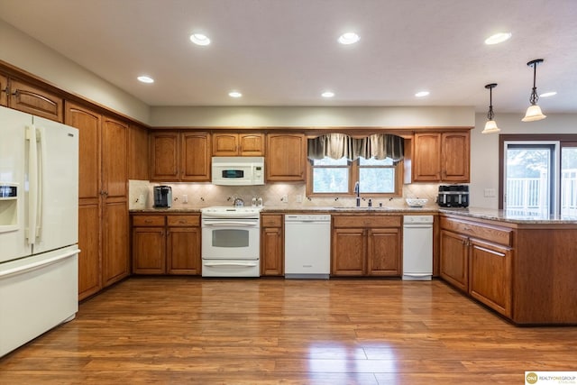 10919 N 69th St, Omaha, NE 68152 - kitchen featuring white appliances, a sink, brown cabinetry, wood finished floors, and recessed lighting
