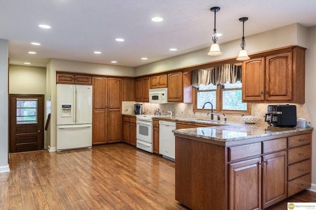 10919 N 69th St, Omaha, NE 68152 - kitchen with white appliances, a sink, brown cabinetry, a peninsula, and recessed lighting