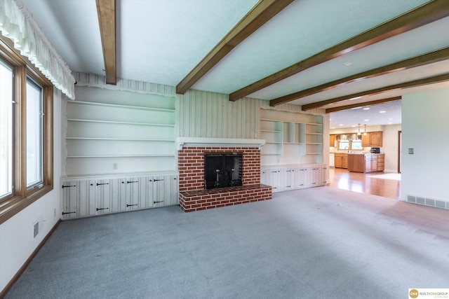 10919 N 69th St, Omaha, NE 68152 - unfurnished living room with light colored carpet, beamed ceiling, baseboards, and a fireplace