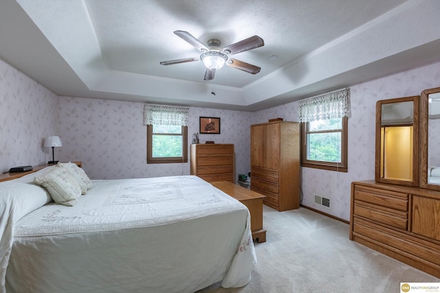10919 N 69th St, Omaha, NE 68152 - bedroom with a tray ceiling, light carpet, a ceiling fan, wallpapered walls, and baseboards