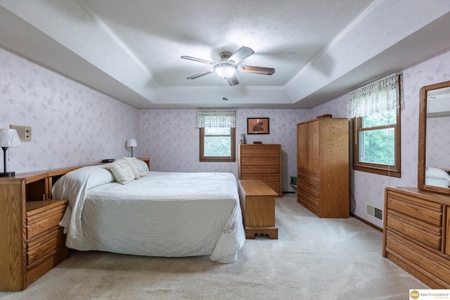 10919 N 69th St, Omaha, NE 68152 - bedroom featuring a tray ceiling, wallpapered walls, light colored carpet, and a ceiling fan