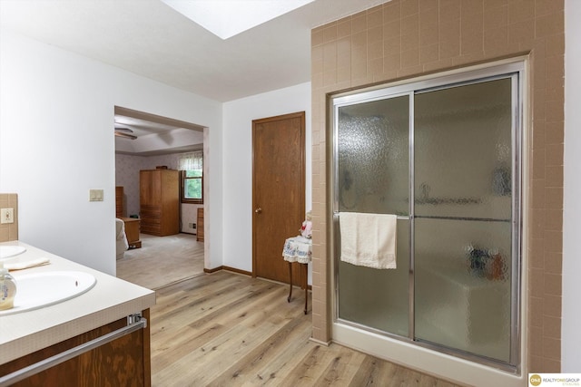 10919 N 69th St, Omaha, NE 68152 - full bath featuring wood finished floors, a stall shower, and double vanity