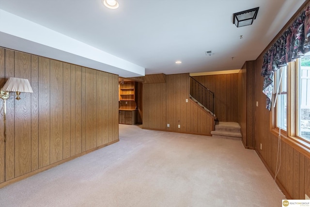 10919 N 69th St, Omaha, NE 68152 - unfurnished living room with wood walls, stairs, and light carpet